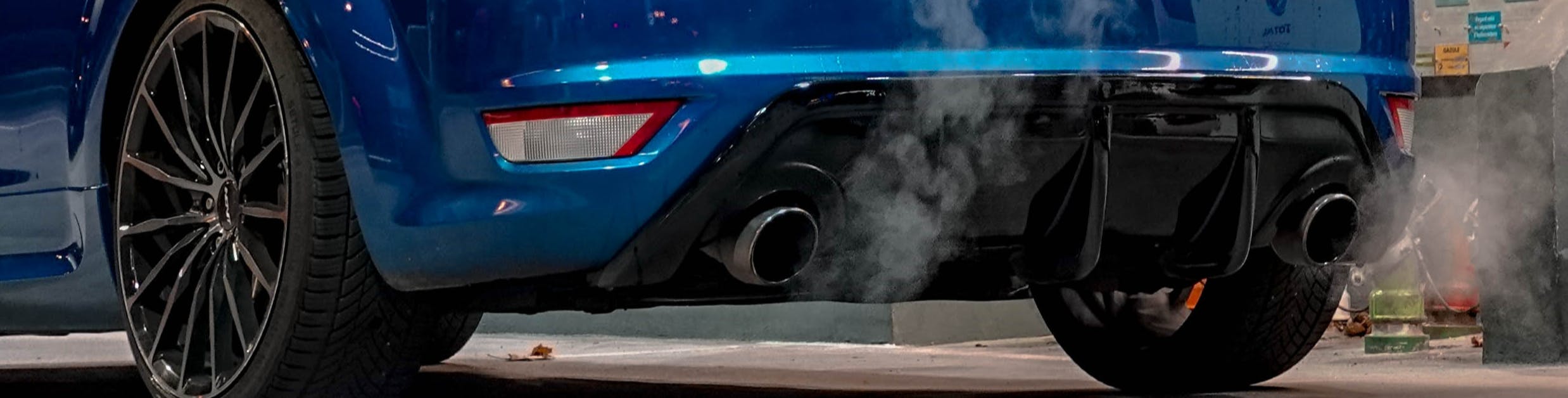 Photo du tuyau d’échappement d’une voiture qui dégage des gaz d’échappement tandis que le véhicule marche au ralenti