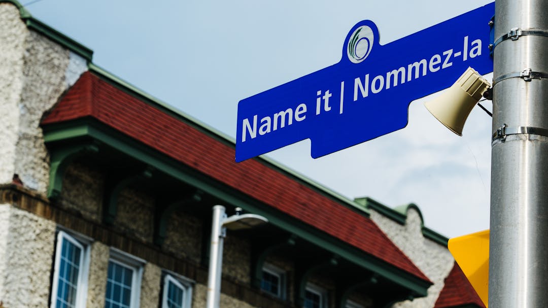 Plaque de rue bleue sur laquelle sont écrits en blanc les mots « Name it » et « Nommez-la ».
