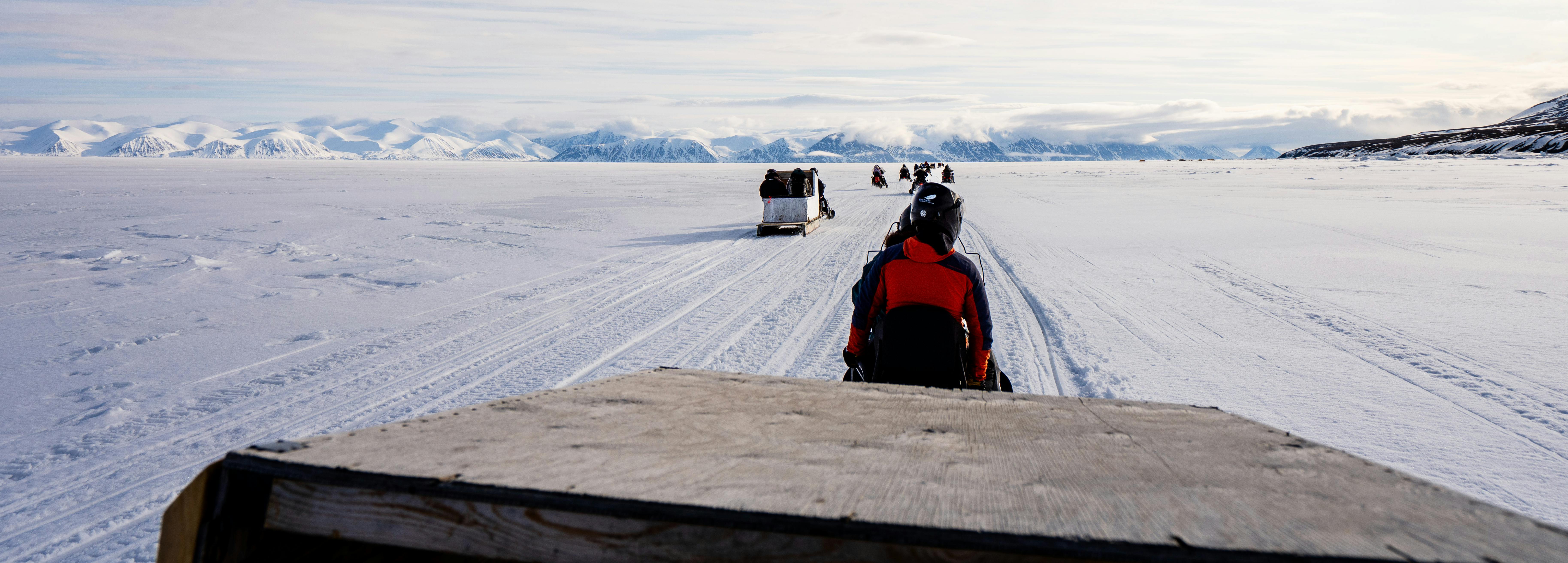 photo prise depuis le remorquage d'une cargaison par une motoneige sur la glace de l'aire marine Tallurutiup Imanga