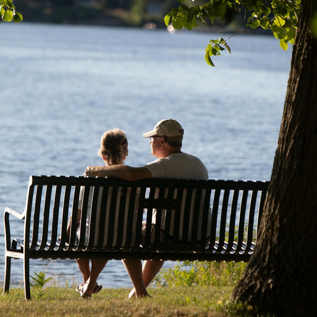 Couple sitting on a bench in Beavermead Park, looking at the Little Lake.