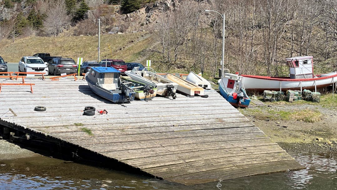 A wooden structure on the water with boats 