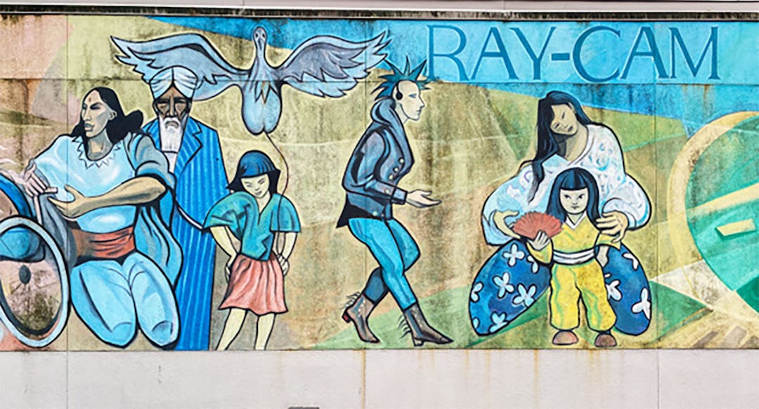Picture of a colourful wall mural that shows a diverse group of people as well as text that reads "RAY-CAM"