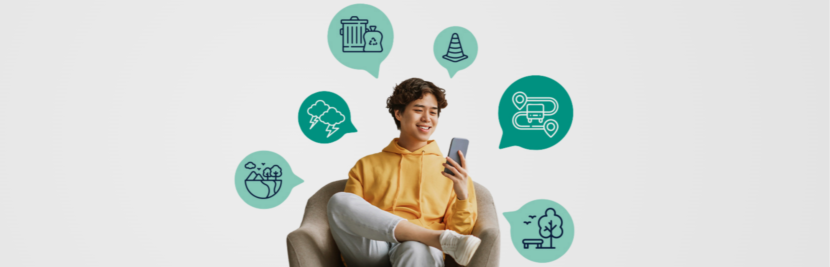 A boy sitting on an armchair looking at his phone. 