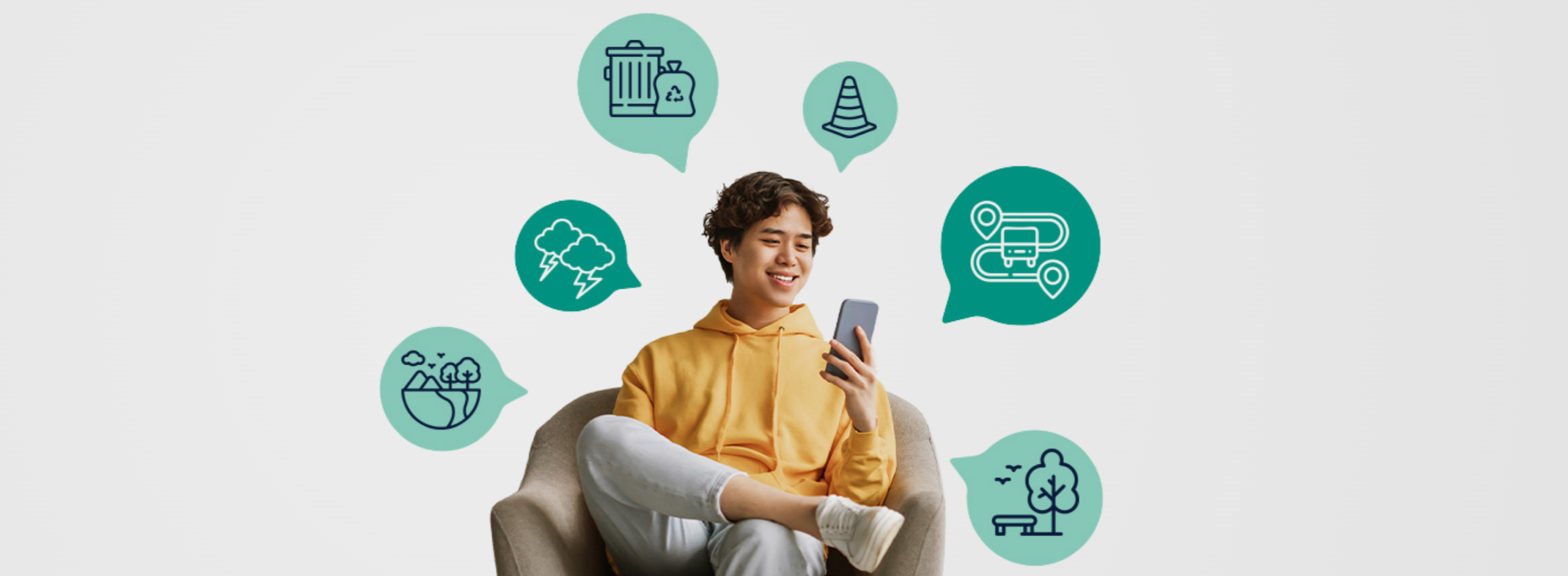 Un garçon assis sur un fauteuil qui regarde son téléphone.