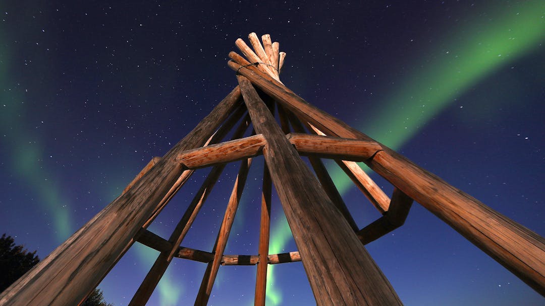 Photo by George Fisher of a Teepee under the Aurora at Edhaa National Historic Site in 2018