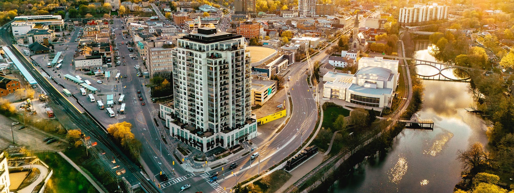 Aerial view of downtown Guelph at sunset showing roads, bridges over the river and the transit hub 