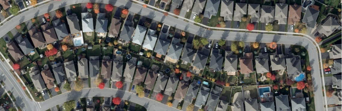 Aerial view of a suburban neighbourhood with rows of houses trees lining the streets.