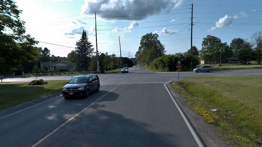 four-way stop intersection at Towerhill Road and Lily Lake Road with vehicles travelling through