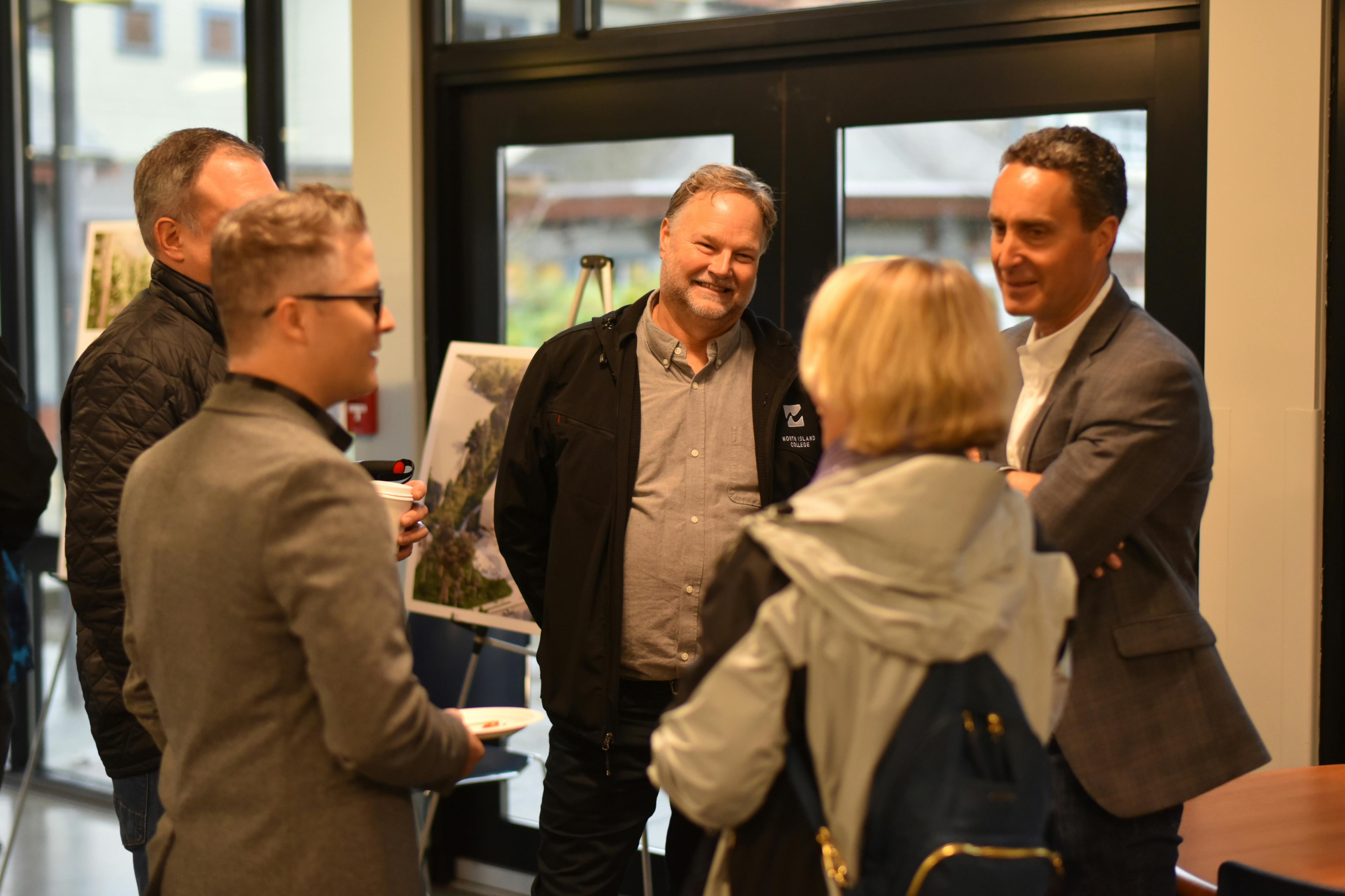 Chris Udy (centre), NIC Director of Capital Projects, and Allan Beron, President, Urban One, talk to people after the blessing.
