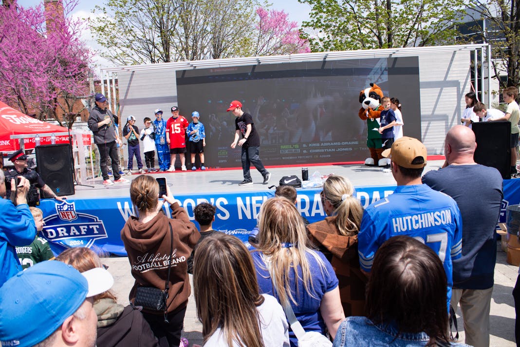 NFL draft event where people are watching kids performing on a stage