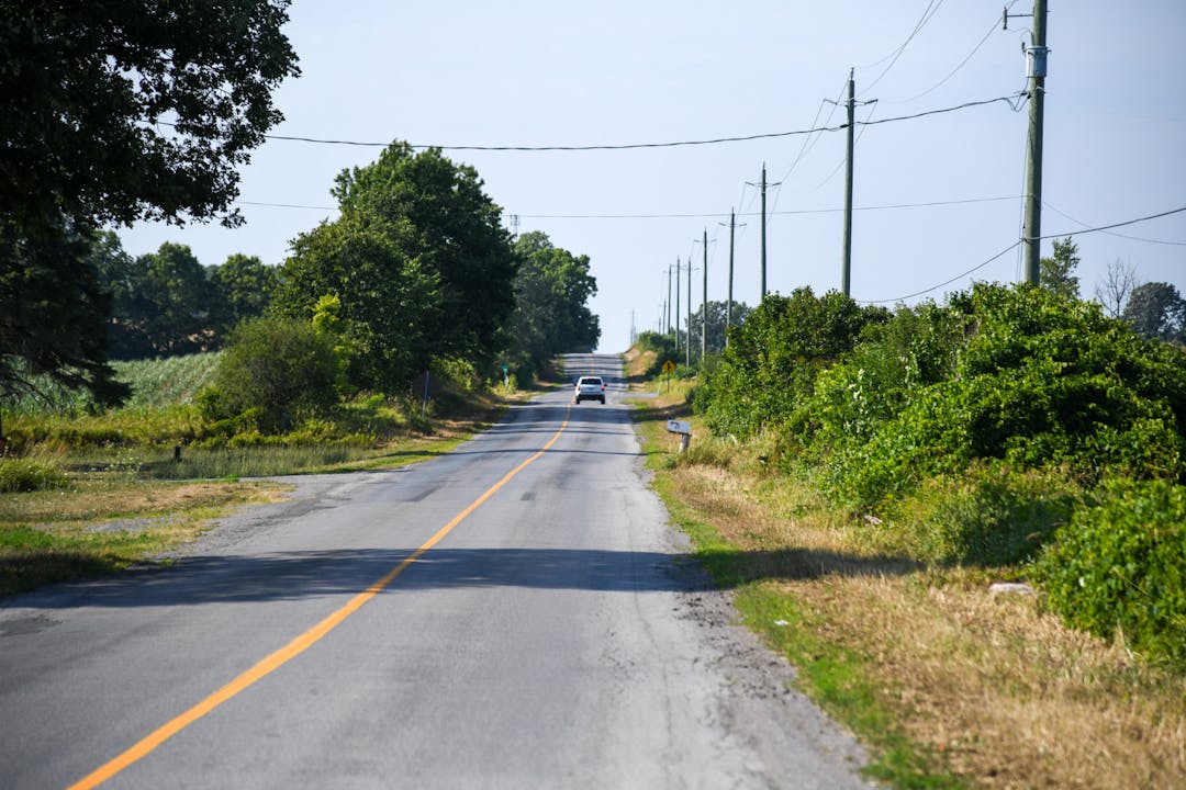 Photo of Phillipston Road with a car driving on the right side.
