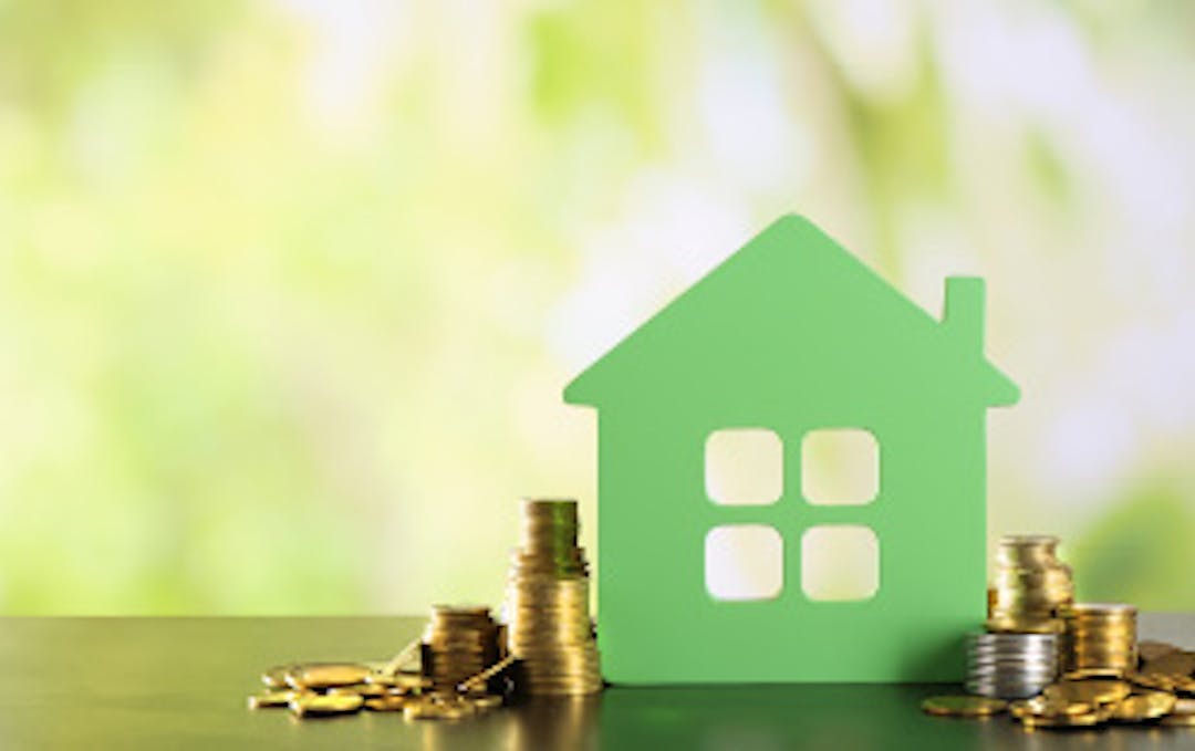 photo of a paper house with coins around it