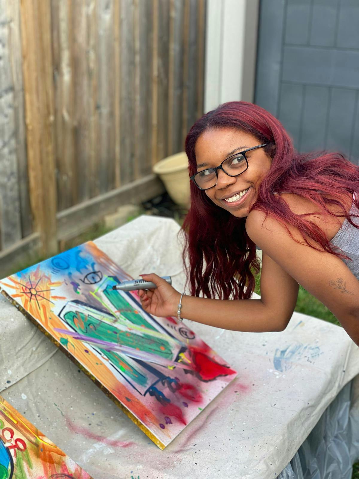 Participant smiling while painting at canvas.