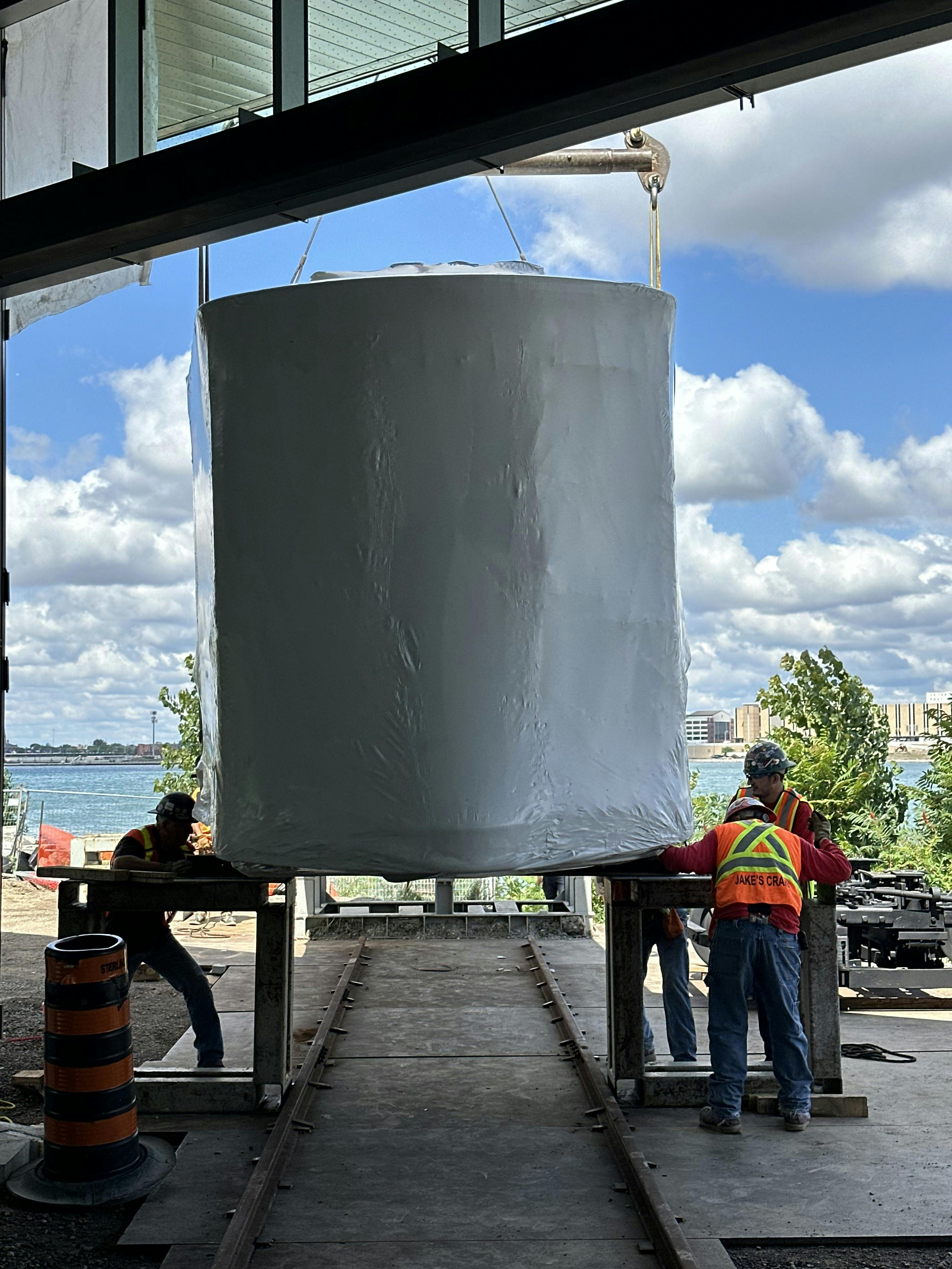 Construction workers moving a piece of the beacon into the building on the water front.