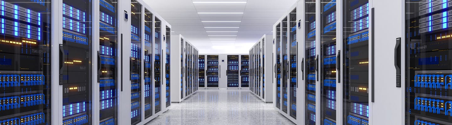 Photo of the interior of a data centre, depicting a long white hallway with rows of servers lining each side