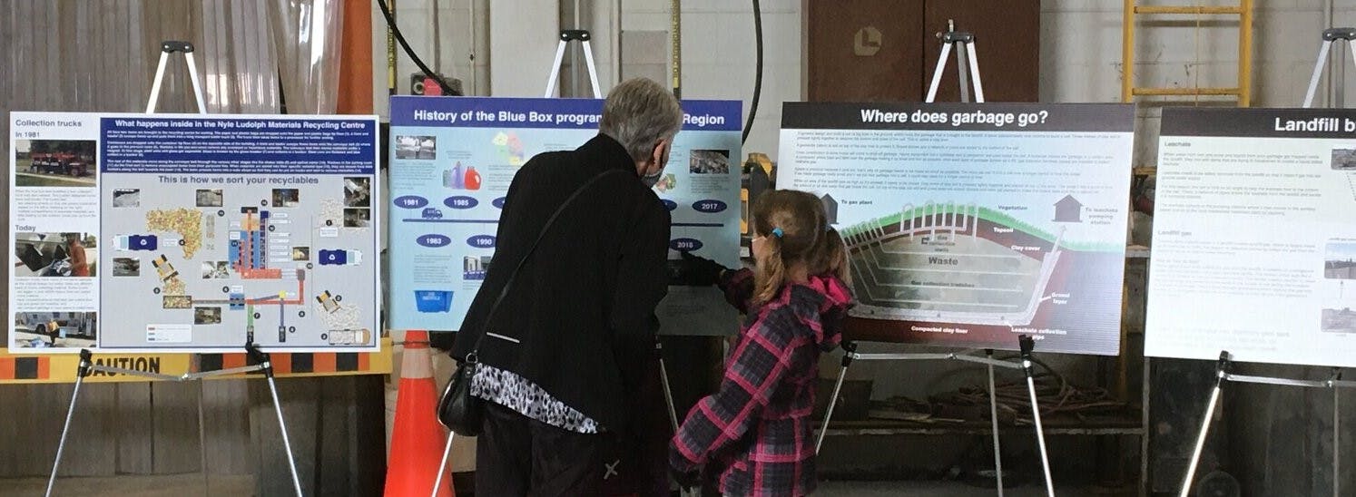 an elderly woman and young girl looking at display boards