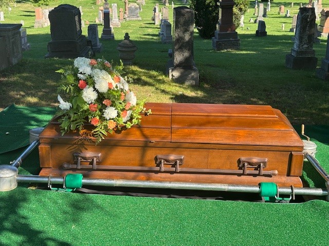 traditional casket burial lot with an upright or flat monument