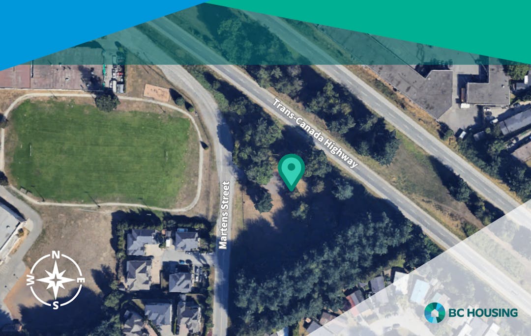 Aerial view of Martens Street and Trans-Canada Highway with a green pin near trees, homes, and a grassy field.
