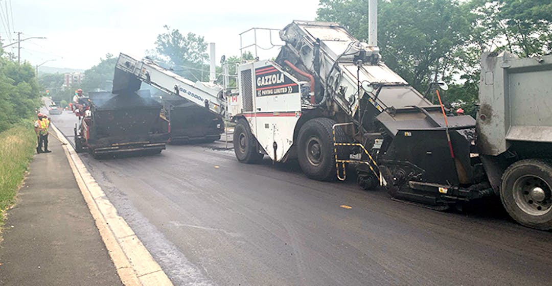 road restructuring with trucks applying asphalt  to roads.