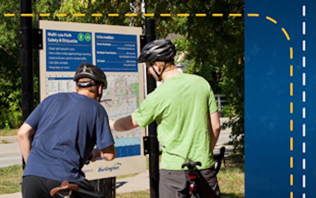 Two bike riders looking at a trail map
