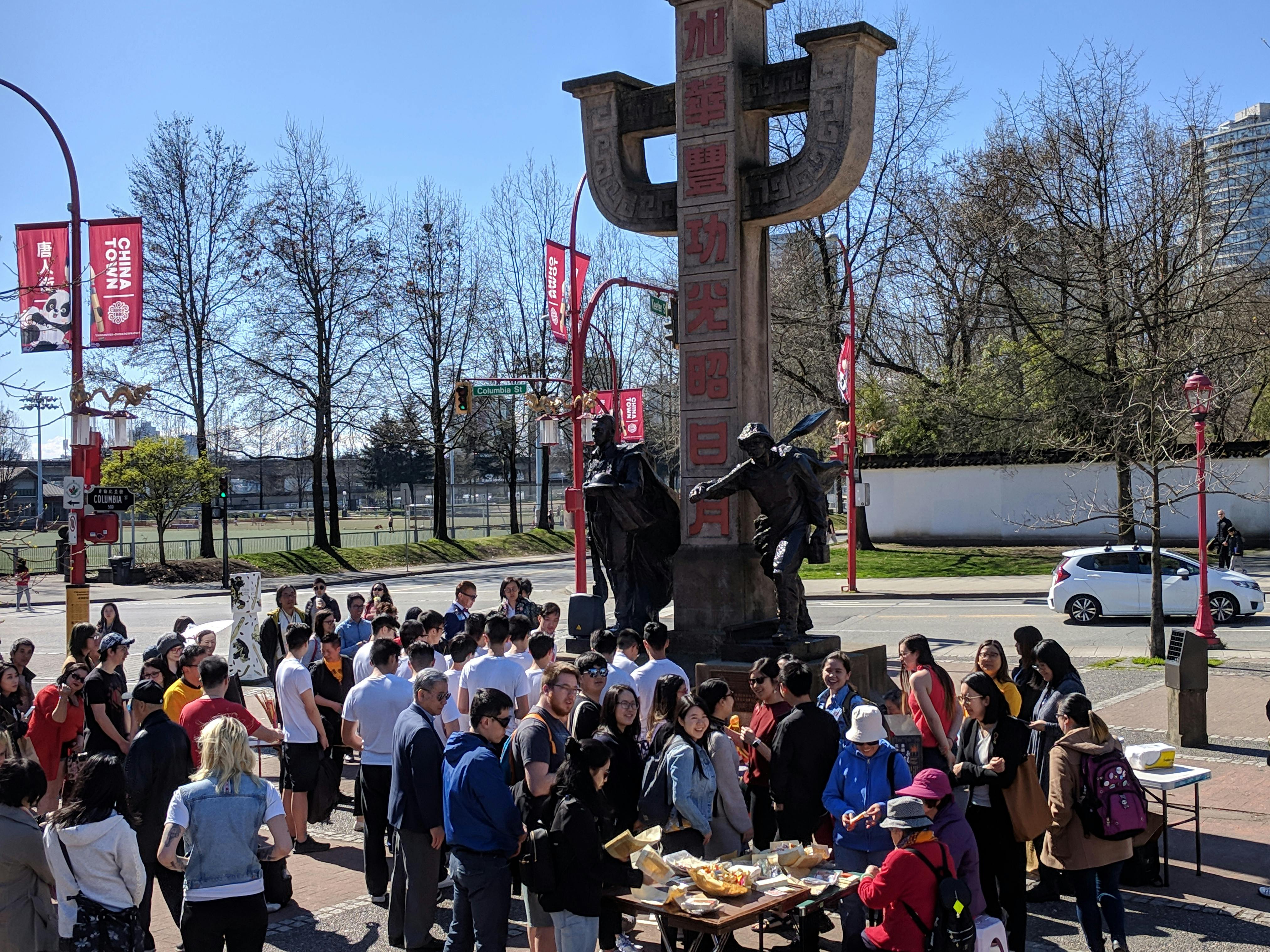 A youth group gathers on Memorial Square sharing food and socializing. 