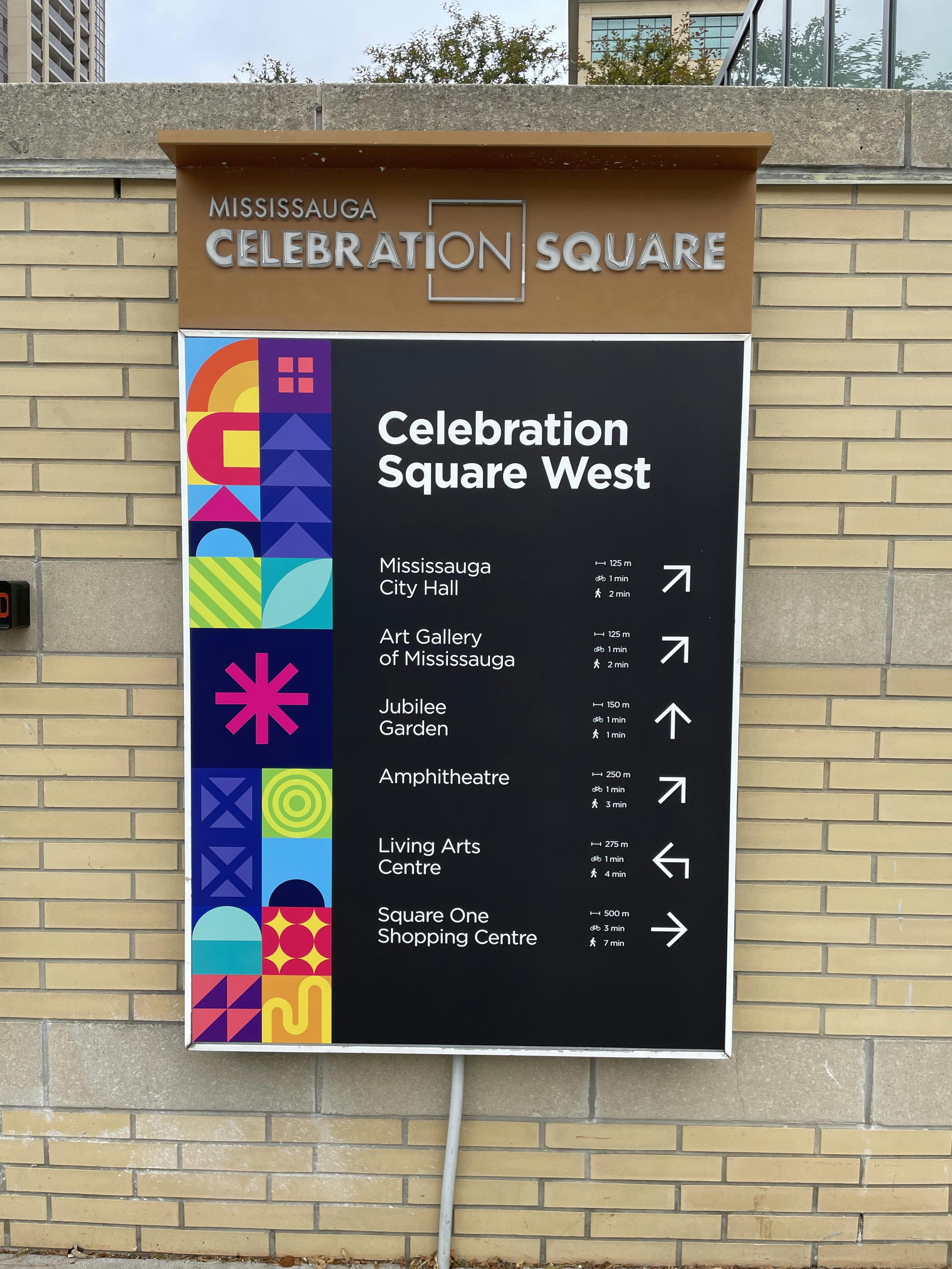 Sign for Celebration Square West in Mississauga, displaying directional arrows and distances to various local attractions.