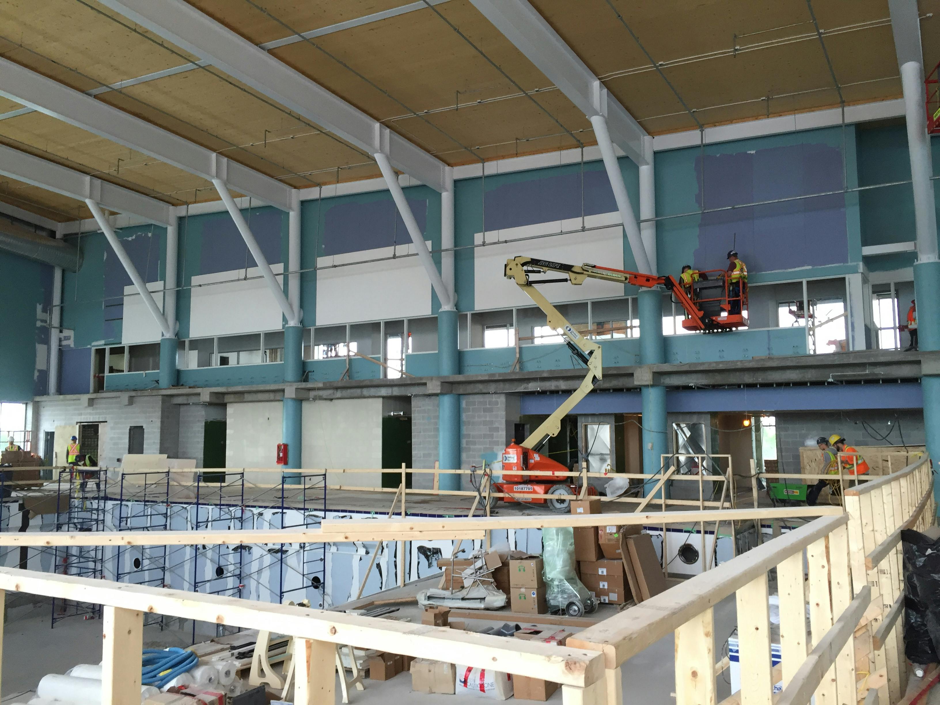 workers installing sound-reducing panels on ceiling and walls of Aquatic Centre, June 22nd