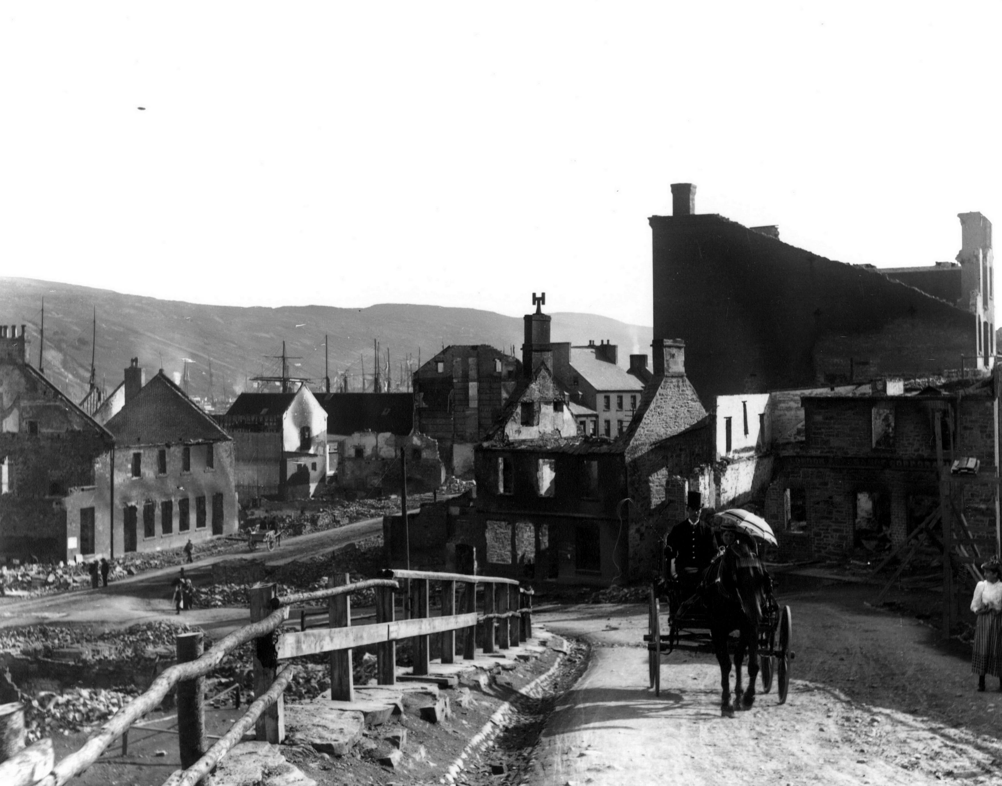 1892: A horse and buggy coming up McBride's Hill after the Great Fire of 1892. The ruins of part of Water Street are in the background.