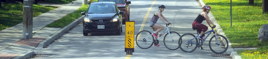 The Cycling and Trails Master Plan People travelling down a cycling route on a street that features a flexible delineator.
