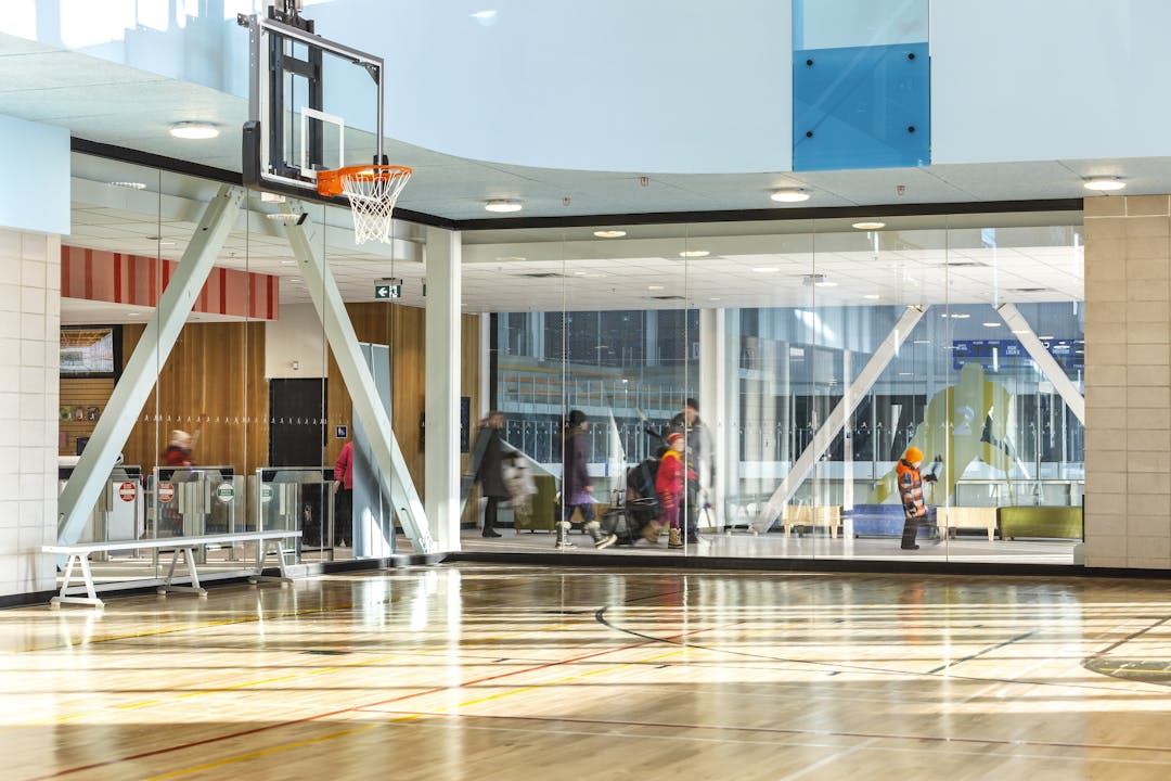 Image d'un gymnase intérieur avec une vue à travers la vitre sur le couloir d'un centre récréatif