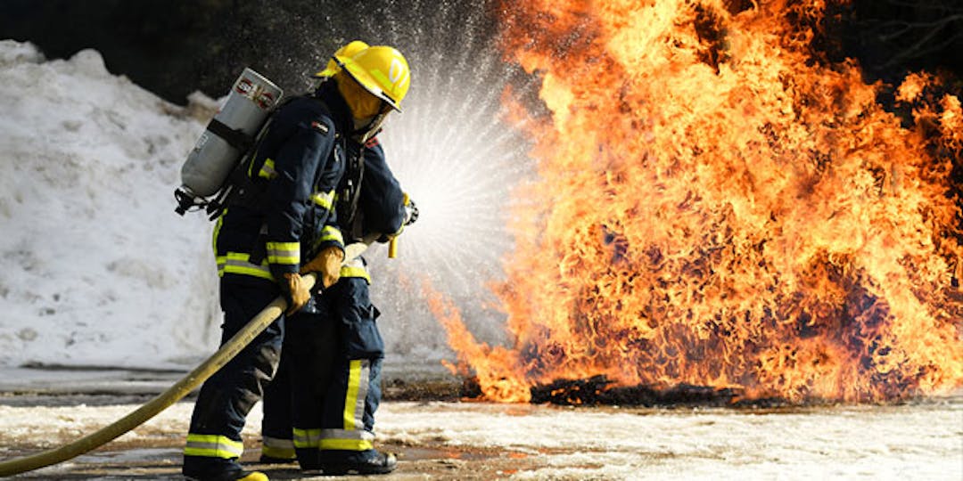 Become A Firefighter two firefighters water hosing a blaze