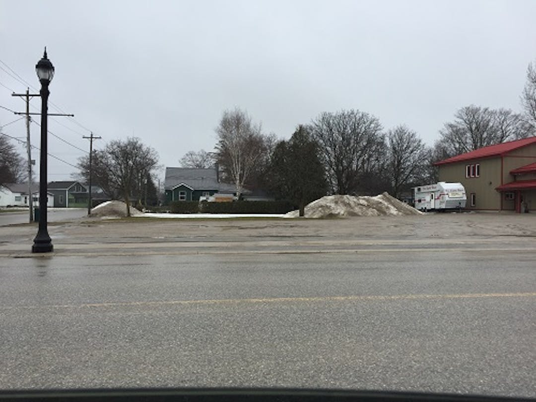 Before photo of the gravel parking lot and grass area